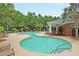 A community pool featuring a zero entry, tanning deck, and covered seating area surrounded by palms and lush landscaping at 350 Cypress Walk Way, Wando, SC 29492