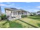 Wide shot of a green backyard with a patio, grill, and screened porch with an outdoor fan at 3537 Crosstrees Ln, Mount Pleasant, SC 29466