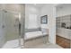 Bright bathroom featuring a walk-in shower, soaking tub, window, and walk-in closet with custom shelving at 3537 Crosstrees Ln, Mount Pleasant, SC 29466