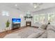 Bright living room with a cozy fireplace, large windows, ceiling fan, and comfortable neutral colored sofa at 3537 Crosstrees Ln, Mount Pleasant, SC 29466