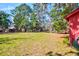 Expansive grassy backyard with mature trees offering shade and beauty, as well as an outbuilding for storage at 4715 Highway 165, Meggett, SC 29449