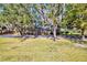 Inviting front yard showcasing a well-maintained lawn, mature trees, and the charming facade of the home at 4715 Highway 165, Meggett, SC 29449