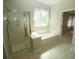 Relaxing bathroom featuring a walk-in shower and a soaking tub by a window at 5008 Northfield Ct, Charleston, SC 29414