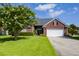 Well-maintained brick home with a two-car garage, lush lawn, and a tree-lined yard at 5008 Northfield Ct, Charleston, SC 29414