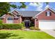 Charming red brick home with a manicured lawn, arched entryway, and attached garage at 5008 Northfield Ct, Charleston, SC 29414
