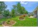 Spacious backyard with lush green grass, bordered flower beds, and a privacy fence, perfect for outdoor activities at 5011 W Liberty Meadows Dr, Summerville, SC 29485