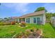 Picturesque backyard featuring lush greenery, colorful flower beds, a screened-in porch, and meticulously kept lawn at 5011 W Liberty Meadows Dr, Summerville, SC 29485