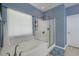 A full bathroom featuring a tiled shower with glass doors, a large soaking tub, and a bright window at 5011 W Liberty Meadows Dr, Summerville, SC 29485