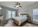 Serene bedroom featuring hardwood floors, a ceiling fan, ample natural light, and a comfortable king-size bed at 5011 W Liberty Meadows Dr, Summerville, SC 29485
