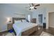 Comfortable bedroom with hardwood floors, a ceiling fan, a king-size bed, and a view into the attached bath at 5011 W Liberty Meadows Dr, Summerville, SC 29485