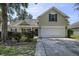 Two story home with green lawn, flowering bushes and attached garage on a sunny day at 5011 W Liberty Meadows Dr, Summerville, SC 29485