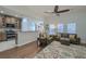 Open-concept living room featuring hardwood floors, comfortable leather seating, and abundant natural light from large windows at 5011 W Liberty Meadows Dr, Summerville, SC 29485