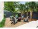 Backyard features outdoor seating around a fire pit, gravel, palm trees and privacy fence at 509 Klein St, Mount Pleasant, SC 29464