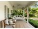 Charming front porch with a hanging daybed, cushioned seating, and a view of the landscaped front yard at 509 Klein St, Mount Pleasant, SC 29464