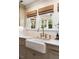 Close-up of a kitchen featuring a farmhouse sink with brass fixtures and a marble countertop at 509 Klein St, Mount Pleasant, SC 29464