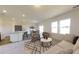Open-concept living room with modern decor, large windows, and adjacent dining and kitchen areas at 5302 Bending Flats Way, Summerville, SC 29485