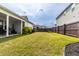 Manicured backyard features green grass, a dark wood fence, and a covered patio for comfortable outdoor living at 558 Pendleton Dr, Moncks Corner, SC 29461