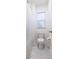 Bright bathroom features a toilet, a shower with a curtain, gray tile flooring, and a window with blinds at 558 Pendleton Dr, Moncks Corner, SC 29461