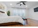 Bright main bedroom with white linen, dark-stained floors, ceiling fan, and a sunny window at 558 Pendleton Dr, Moncks Corner, SC 29461