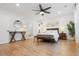 Expansive main bedroom with ceiling fan, stylish bench, hardwood floors, art, lamps, and a plant at 558 Pendleton Dr, Moncks Corner, SC 29461