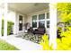 Covered patio features wicker furniture, a green and white patterned rug, and lush landscaping for privacy at 558 Pendleton Dr, Moncks Corner, SC 29461