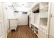 Spacious walk-in closet with custom white cabinets, drawers, shelving, and hardwood floors at 558 Pendleton Dr, Moncks Corner, SC 29461