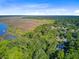 Scenic aerial view of the home nestled among mature trees, neighborhood, and gorgeous marsh views at 7074 W Constellation Dr, North Charleston, SC 29418