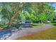 Charming home with a circular driveway, lush green lawn, and mature trees at 7074 W Constellation Dr, North Charleston, SC 29418