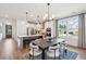 Open-concept dining room featuring stylish lighting, large windows, and a view of the modern kitchen at 725 Maynard Ln, Summerville, SC 29486