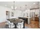 Dining room features a dark wood table, upholstered chairs, modern lighting, and an open flow to the kitchen at 725 Maynard Ln, Summerville, SC 29486