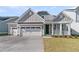 Charming home with a two-car garage, a covered front porch, and a well-manicured lawn at 762 Maynard Ln, Summerville, SC 29486