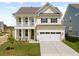 Charming two-story home with yellow siding, a front porch, white columns, and a two-car garage at 774 Maynard Ln, Summerville, SC 29486