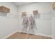 Walk-in closet with white wire shelving, wood-look floors, and gray robes on hangers at 786 Maynard Ln, Summerville, SC 29486