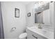 All-white bathroom featuring modern vanity with framed mirror, shower with curtain, and beach-themed decor at 8767 Auburn Dr, North Charleston, SC 29406