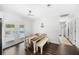Bright dining room with dark wood floors, table with bench seating, and view of the backyard pool at 8767 Auburn Dr, North Charleston, SC 29406
