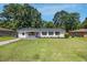 Charming single-story home featuring a neatly manicured lawn and white brick exterior with dark shutters at 8767 Auburn Dr, North Charleston, SC 29406