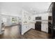 Bright kitchen featuring white cabinetry, stainless steel appliances, breakfast bar, and views to the living area at 8767 Auburn Dr, North Charleston, SC 29406