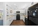 Bright kitchen featuring granite countertops, white cabinetry, modern appliances, and dark floors at 8767 Auburn Dr, North Charleston, SC 29406