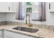 Close-up of a kitchen sink with granite countertop, stylish faucet, and natural light from the window at 8767 Auburn Dr, North Charleston, SC 29406