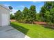 Backyard with deck, green lawn, tree line, and side of the home at 9079 Parlor Dr, Ladson, SC 29456