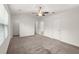 Spacious main bedroom featuring neutral carpeting, a ceiling fan, and multiple closets and entryways at 9079 Parlor Dr, Ladson, SC 29456
