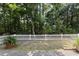 Lush backyard showcasing mature trees, a white picket fence, and a tranquil outdoor setting at 9091 Delancey Cir, North Charleston, SC 29406