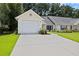 Inviting home exterior showcasing lush landscaping, a well-manicured lawn, and a paved driveway at 9091 Delancey Cir, North Charleston, SC 29406