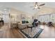 Bright living room with vaulted ceiling, fan, wood floors, sofa, chairs, area rug and bay window at 9091 Delancey Cir, North Charleston, SC 29406