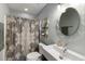 Bathroom with patterned shower curtain, rounded mirror, and modern vanity at 1033 Mathis Ferry Rd, Mount Pleasant, SC 29464