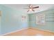 Light blue bedroom featuring a ceiling fan, hardwood floors, and two windows with built-in shelving at 105 Greendale Ct, Summerville, SC 29485
