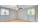 Bright bedroom featuring hardwood floors, ceiling fan, and windows draped with lace curtains at 105 Greendale Ct, Summerville, SC 29485