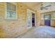 Enclosed porch with a brick wall, tile floor, ceiling fan, and door leading inside the home at 105 Greendale Ct, Summerville, SC 29485