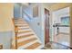 A beautiful home staircase featuring natural wood stairs and white risers with a view into the kitchen at 105 Greendale Ct, Summerville, SC 29485