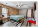 Inviting bedroom with light gray walls, wood accent wall, ceiling fan, wood look floors, and a window at 106 Maypop Dr, Goose Creek, SC 29445